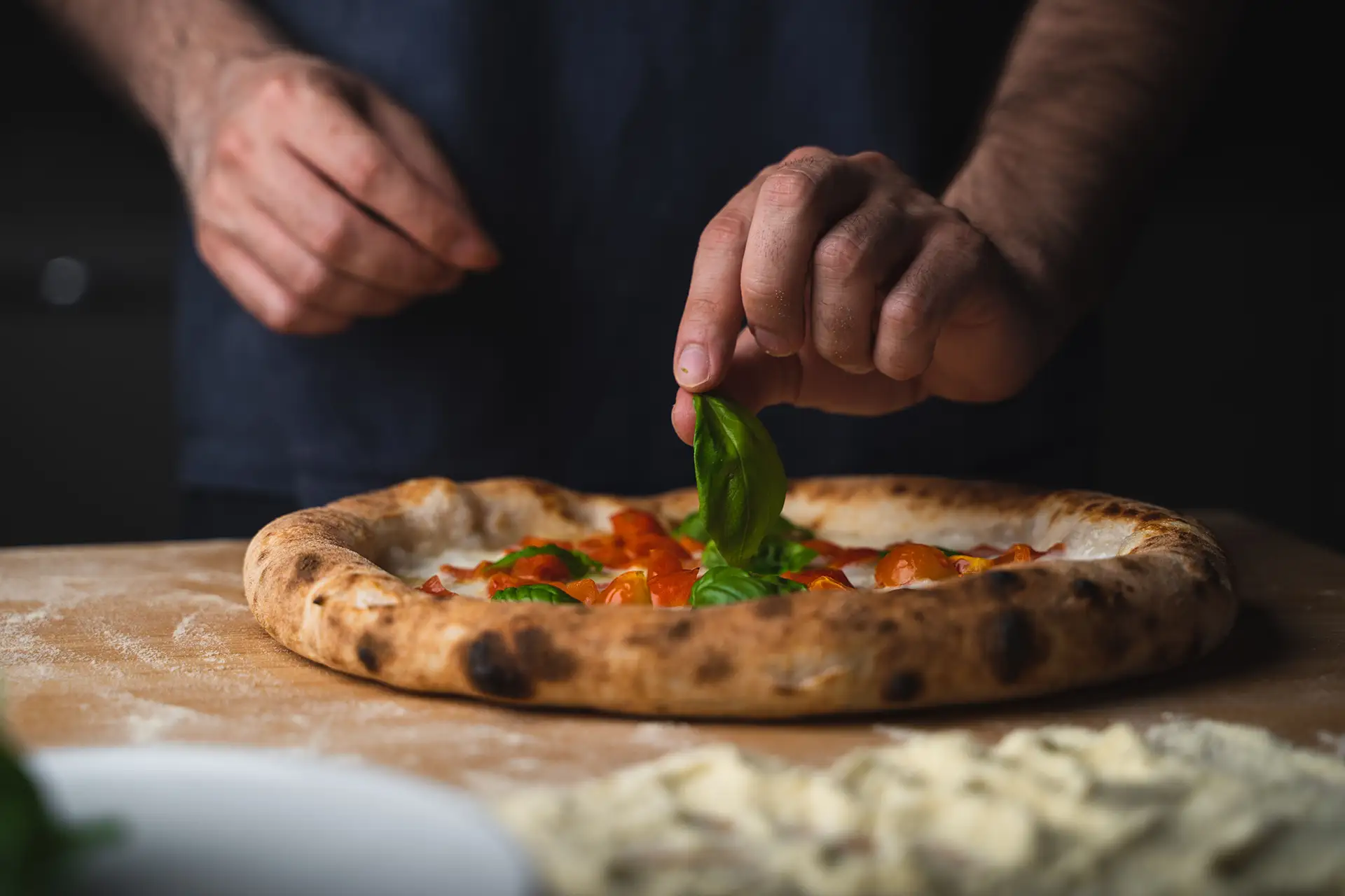 Uomo Guarnisce Pizza Con Basilico